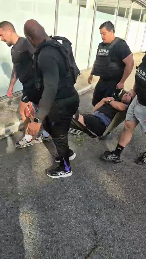 Stagiaires équipés de gilets porte-plaques tractant un blessé sur un brancard souple lors d'un exercice d'extraction