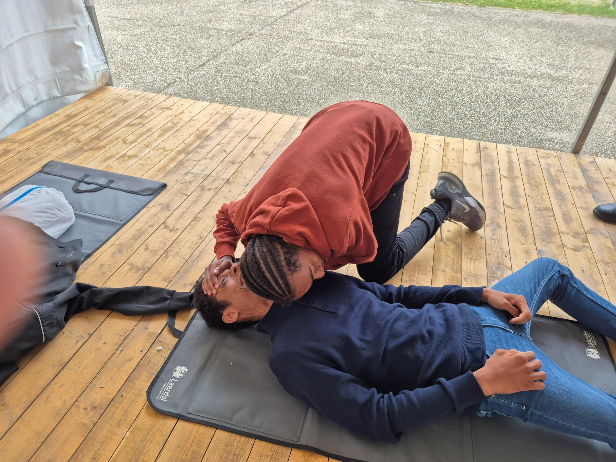 Stagiaire vérifiant la respiration d'une victime allongée au sol